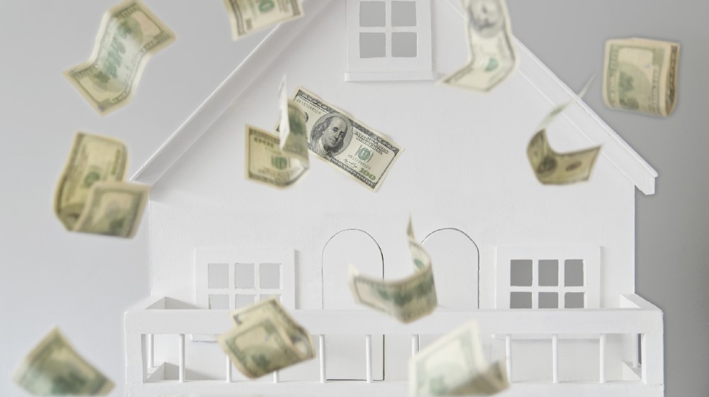 US dollar notes falling over against a white house | The US Housing Boom Is Now Officially Over | featured