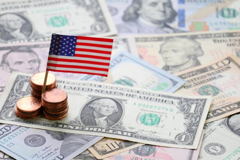 US flag sign and Dollar cash banknote and coin | US Economy Grew by 5.7% in 2021