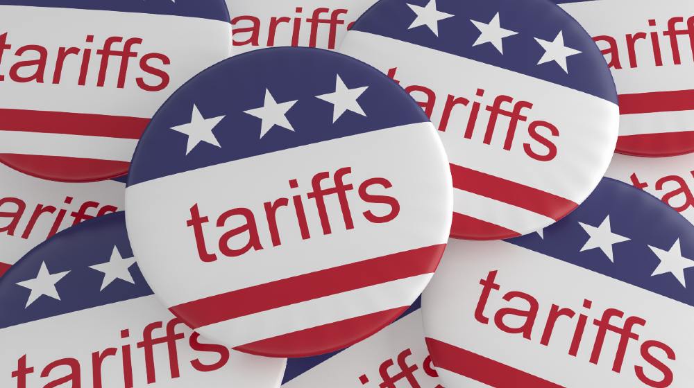 USA Politics News Badges Pile of Tariffs Buttons With US Flag | Businesses Blame Import Tariffs For Inflation | Featured