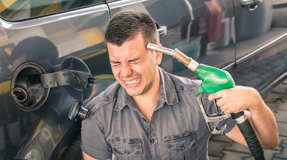 Young adult shooting himself over crazy petrol and fuel prices-$3 per gallon gas prices-ss-featured