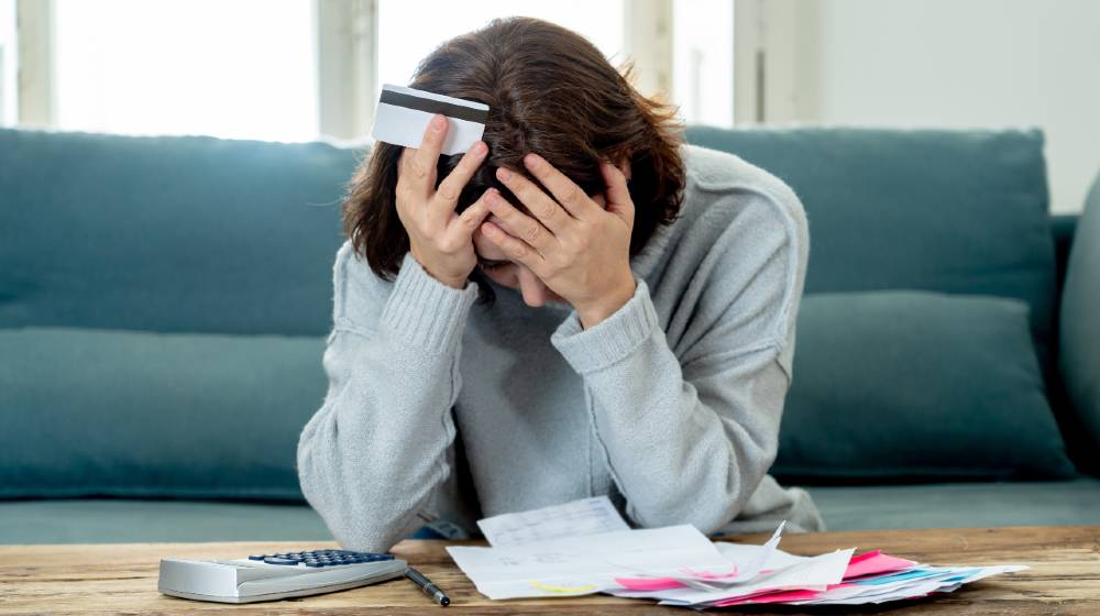 Young attractive woman looking stressed and worried with card payments and home finances | Major Causes of Financial Problems | featured