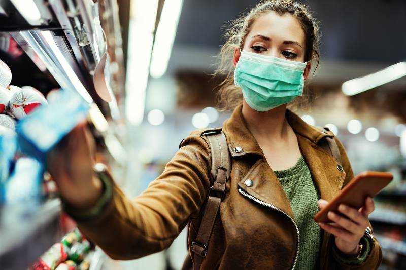 Young woman with face mask using mobile phone | pandemic