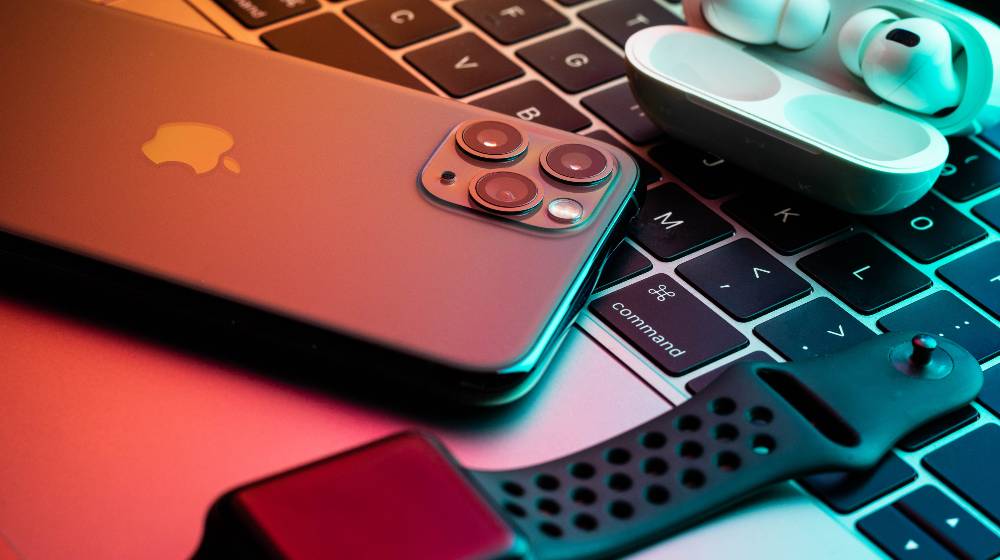 iPhone 11 Pro with AirPods Pro and Apple Watch with a Macbook in the background | Apple Products Are Not Available For Sale or Delivery To Russia | featured