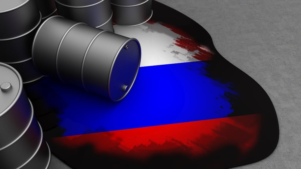 oil waste and russian flag in it | West Faces $300 Per Barrel Prices If They Cut Off Russian Oil | featured