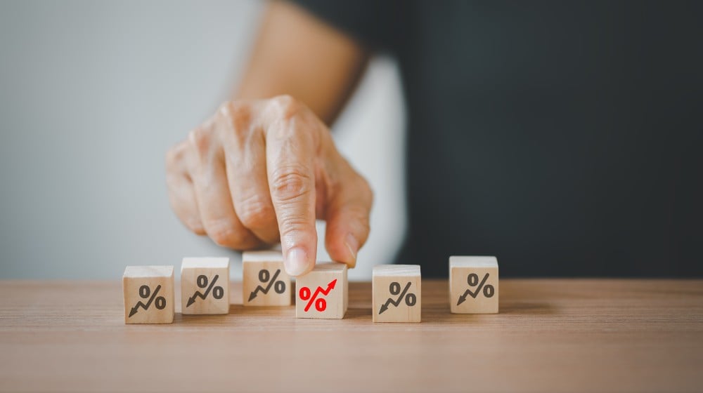 senior hand choosing red increasing percent among black decreasing percent | 5 Factors Impacting Interest Rates! | featured